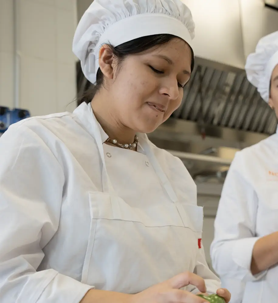 Alumna de hostelería realizando formación práctica de cocina en las instalaciones preparadas del centro Nova FP23 en Madrid.