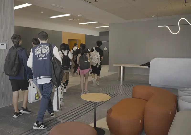 Alumnos con mochilas caminando por el vestíbulo del nuevo centro de formación profesional Nova FP23 en Madrid